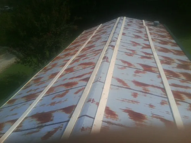 Rusted metal roof panels with new wood purlins before replacement — Storm Damage Roof Repair in New Hampton by Roofing Brothers