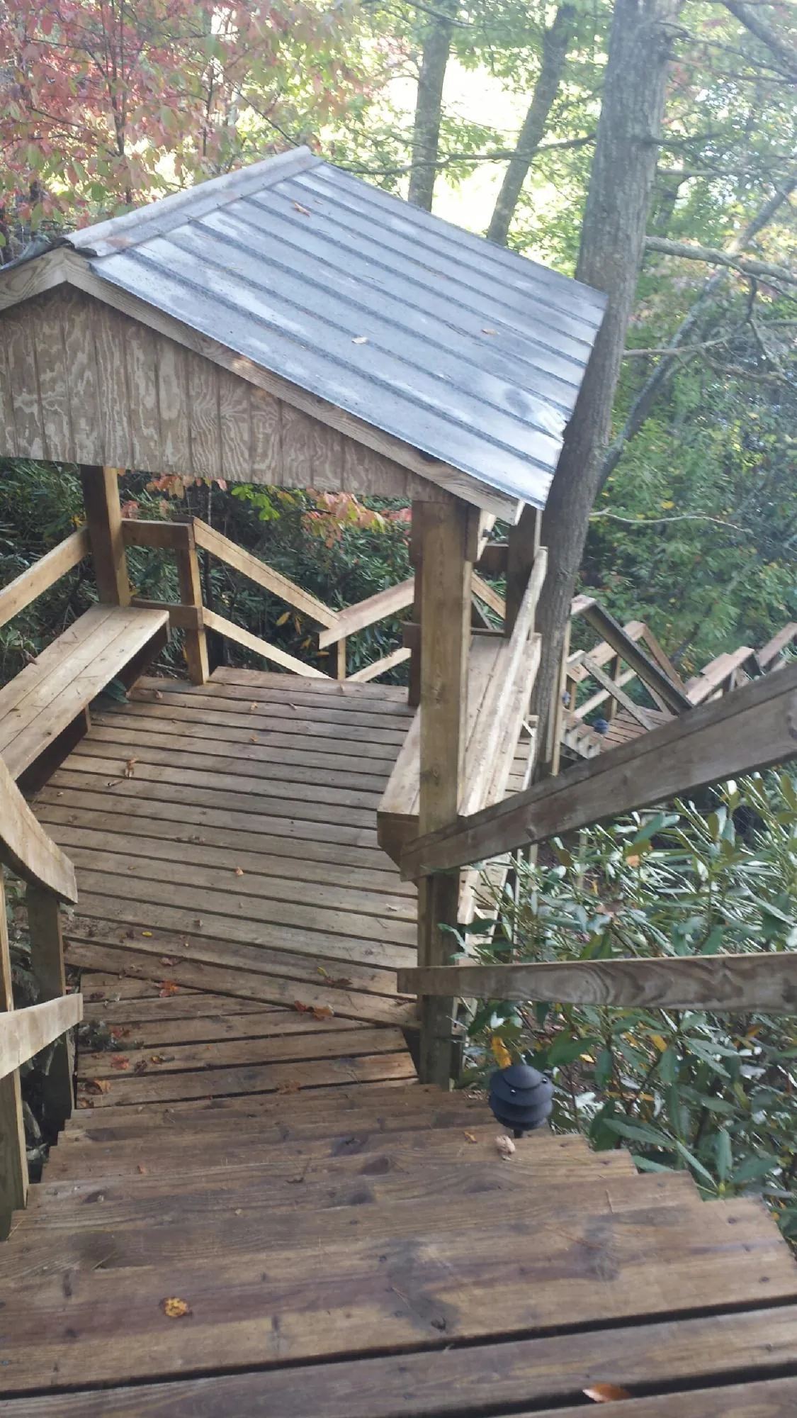 Metal roofed shelter over wooden steps on a wooded walkway — Skylight Repair & Installation work by our crew in New Hampton
