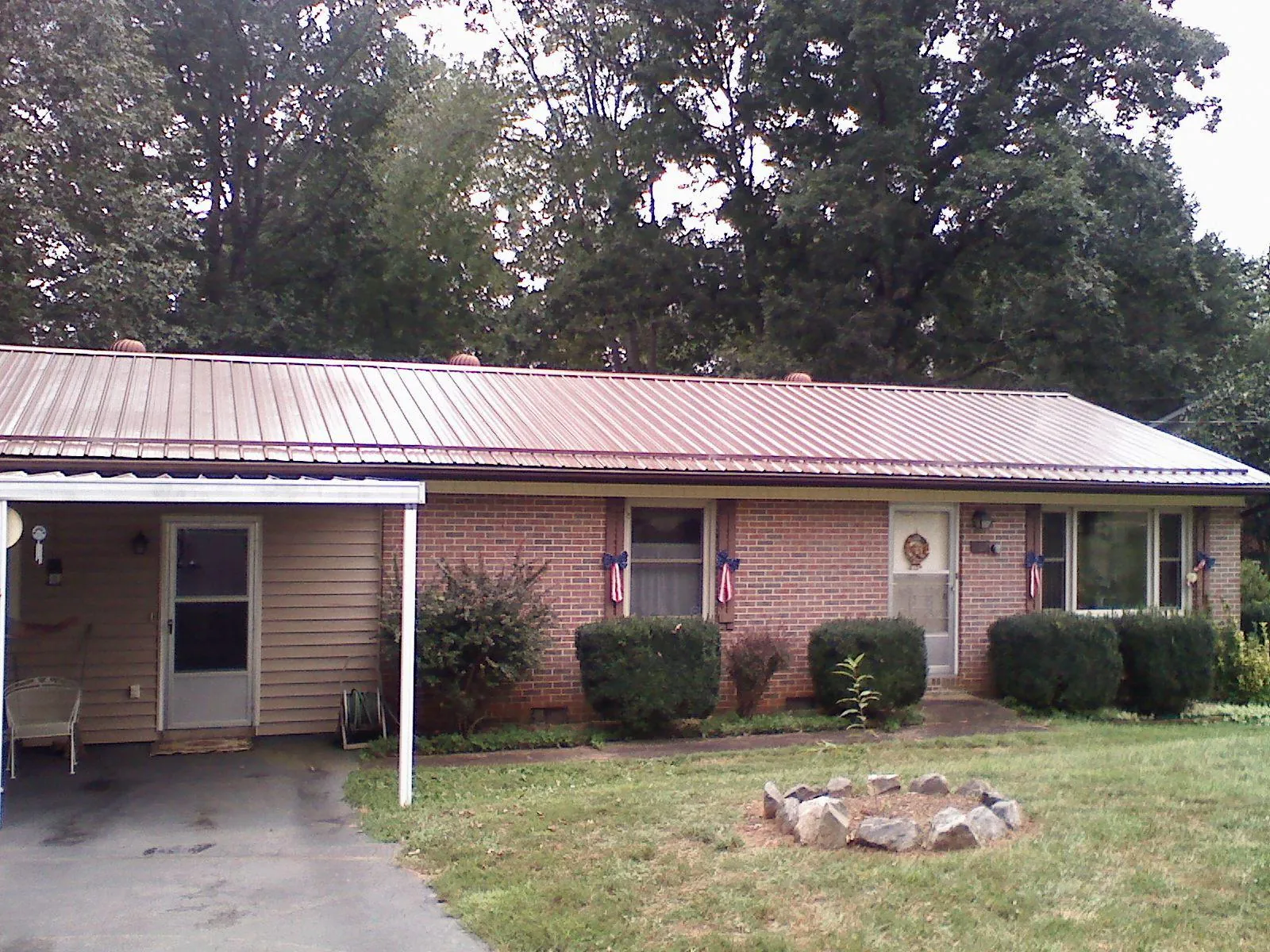Bronze metal roof and carport on a brick ranch home — Roof Repair work by our crew in New Hampton